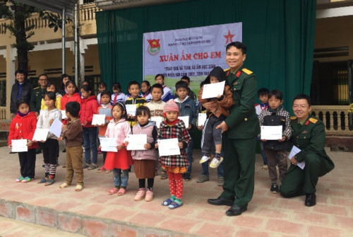 Đại uý Trần Duy Văn - Bí thư Đoàn cơ sở Báo Quân đội nhân dân tặng áo ấm, quà Tết cho HS nghèo