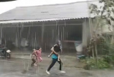 Người cha ôm con đi tránh bão